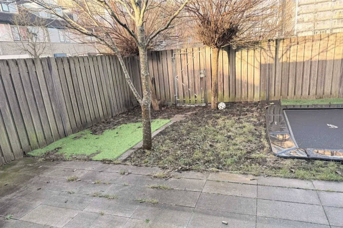 Voor: Achtertuin met kale tegels en modder